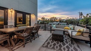 An outdoor patio with a dining table, chairs, and a sofa. - Spacious Beach Retreat, Sleeps 10 | Walk to Gulf (Redington Beach)