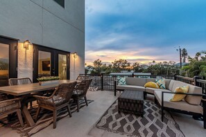 An outdoor patio with a dining table, chairs, and a sofa.