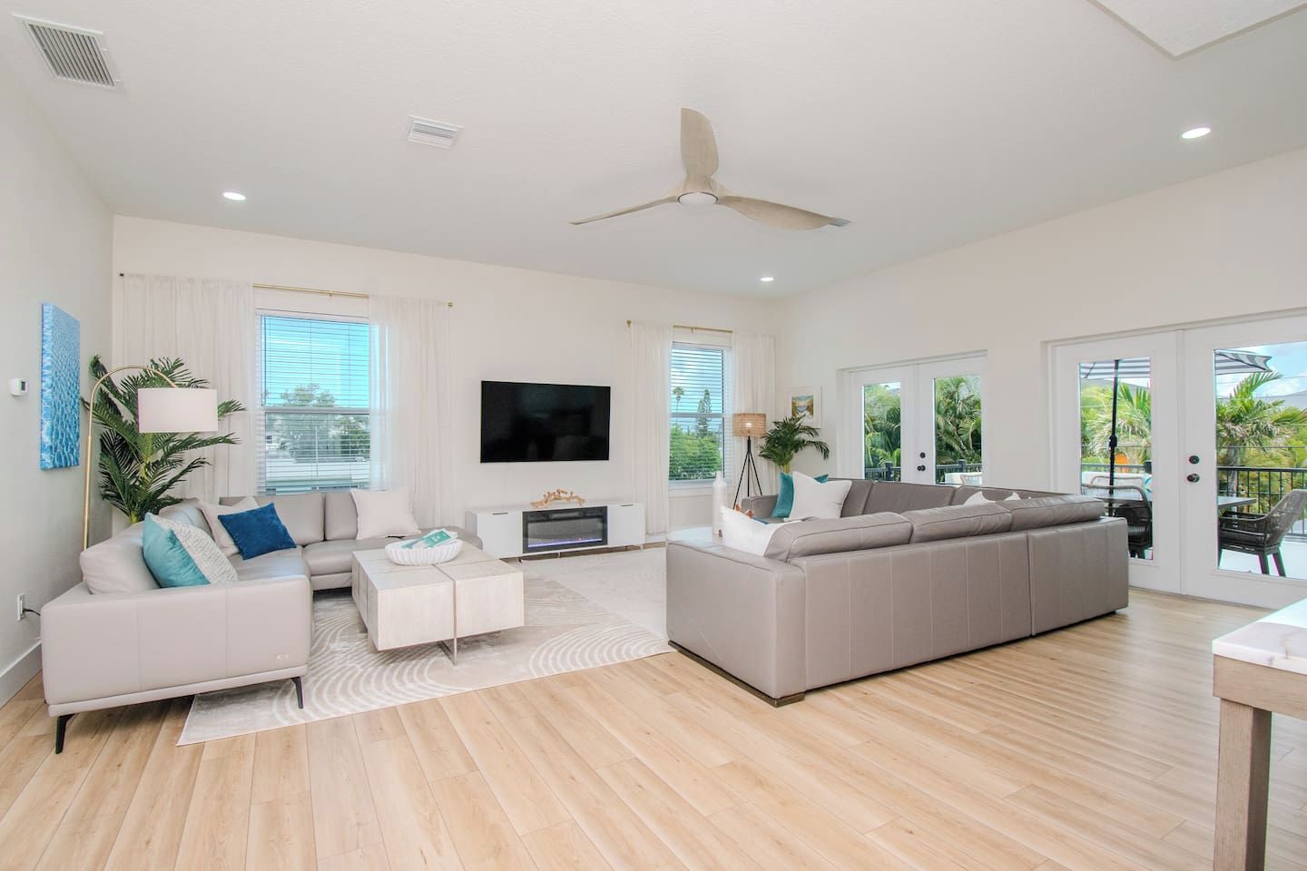 A spacious living room with a large sofa, a coffee table, and a flat-screen TV.