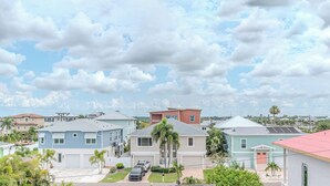 A residential area with houses, a clear sky, and a few palm trees. - Spacious Beach Retreat, Sleeps 10 | Walk to Gulf (Redington Beach)