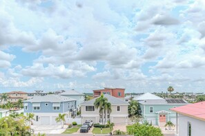 A residential area with houses, a clear sky, and a few palm trees.