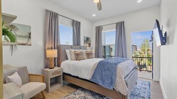 Une chambre à coucher moderne, avec un lit, une table de chevet, une lampe et une vue sur l’extérieur.