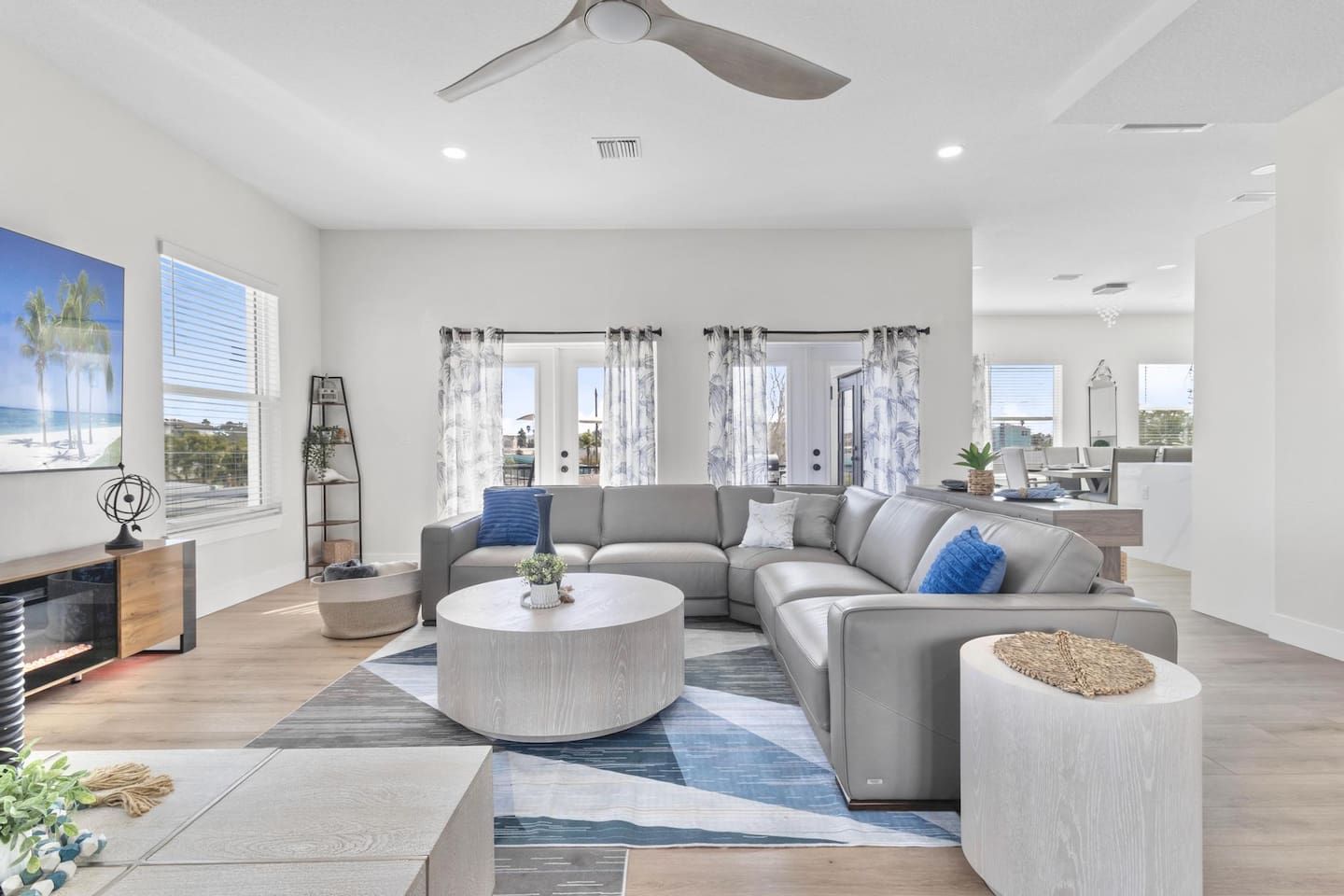 A modern living room with a sectional sofa, a round coffee table, and a fireplace.