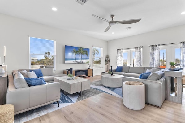 A modern living room with a sofa, coffee table, and a ceiling fan.