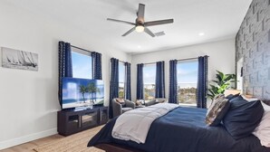 A bedroom with a bed, a TV, and a ceiling fan. - 3 Blocks to Redington Beach | Sleeps 10, 6BR (Redington Beach)