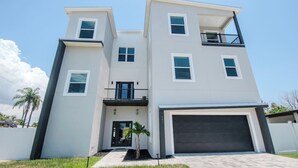 A modern two-story residential building with a garage, a balcony, and a small front yard. - 3 Blocks to Redington Beach | Sleeps 10, 6BR (Redington Beach)