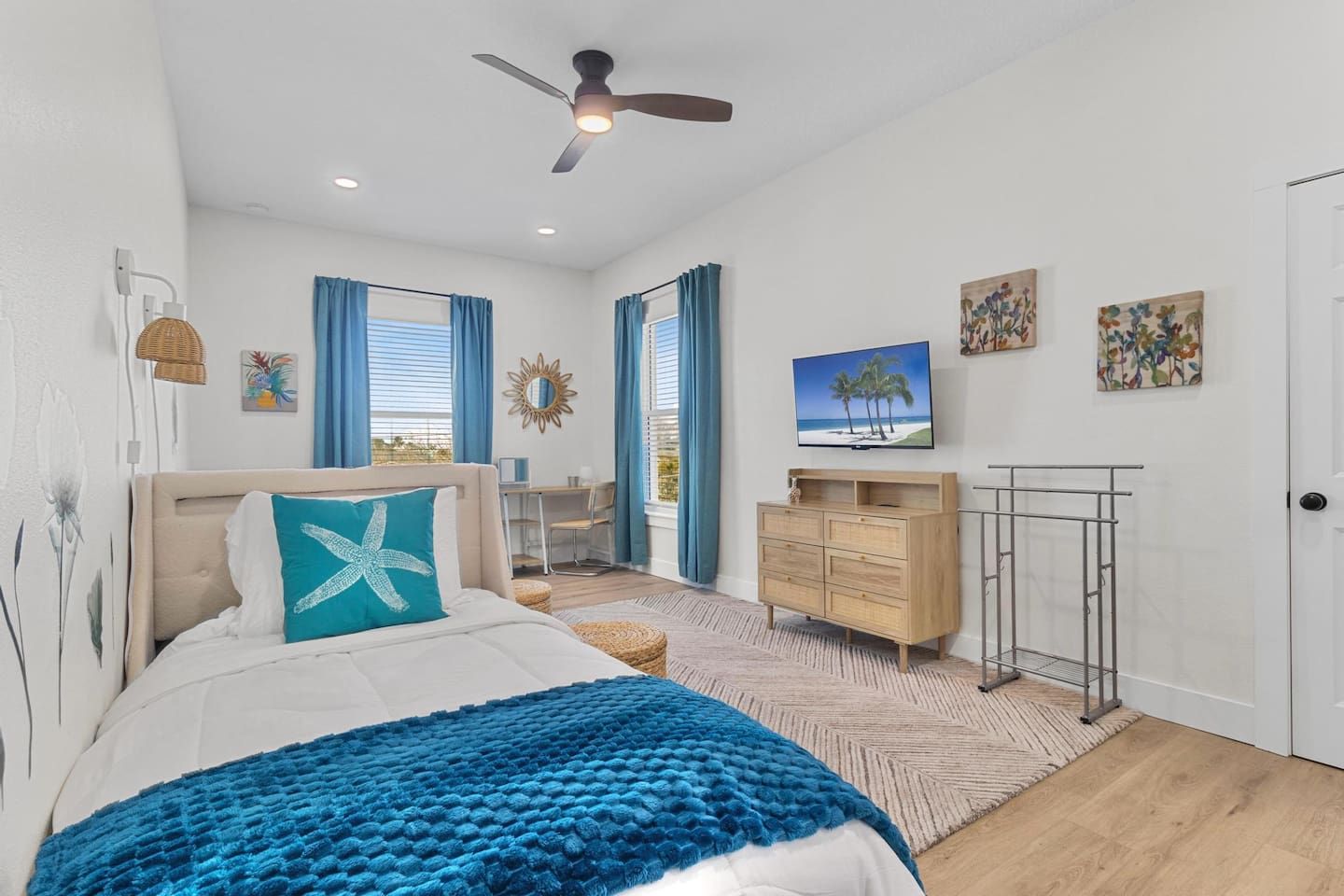 A bedroom with a bed, a desk, a TV, and a wardrobe.