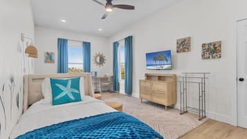 A bedroom with a bed, a desk, a TV, and a wardrobe.
