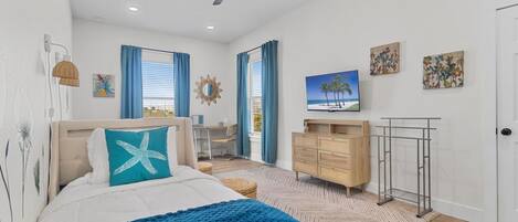 A bedroom with a bed, a desk, a TV, and a wardrobe.
