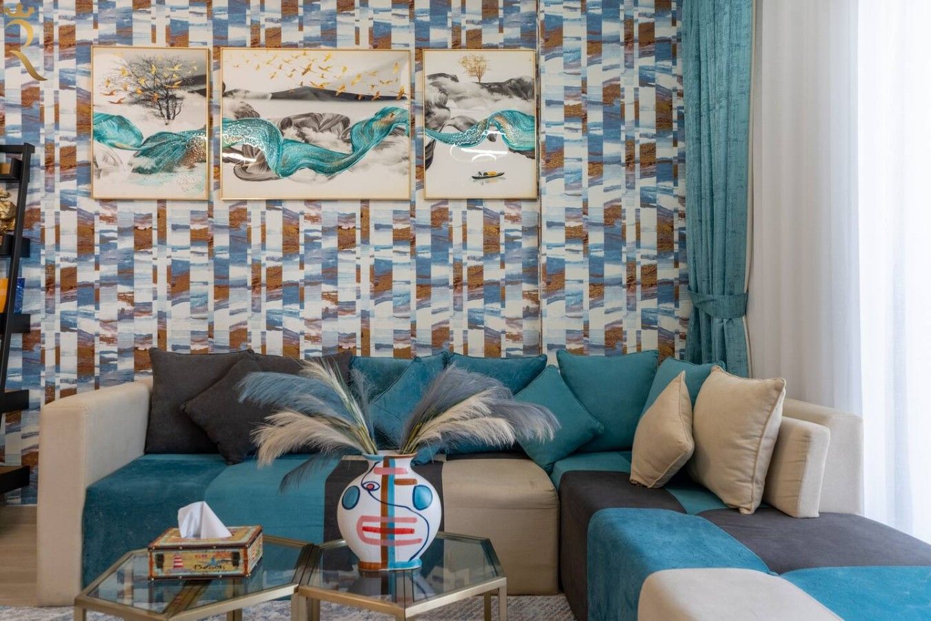 Een woonkamer met behang met een patroon, een bank en een glazen salontafel met decoratieve objecten.