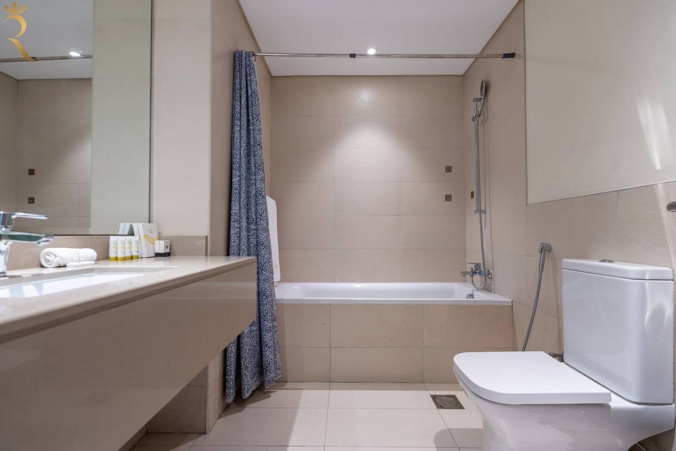 A modern bathroom with a bathtub, toilet, and a vanity with a mirror.