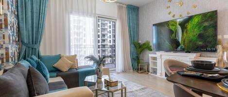 Een moderne woonkamer met een bank, een salontafel, een televisie en een eethoek.