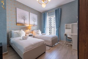 Una habitación de hotel con dos camas, un escritorio y vistas a la ciudad.