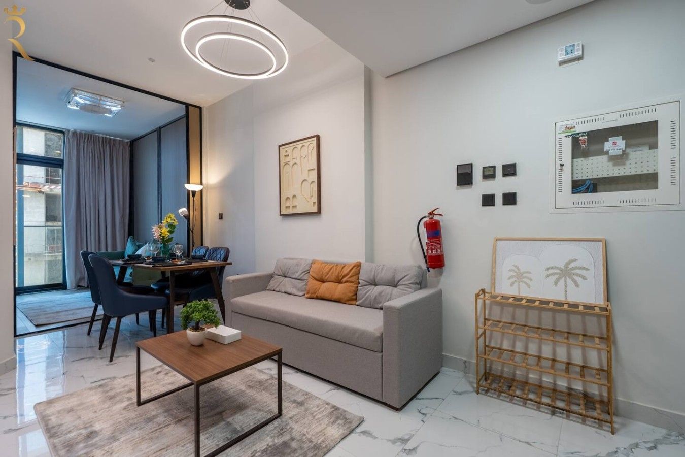 Una sala de estar moderna con un sofá, una mesa de centro y una zona de comedor con sillas y una mesa.