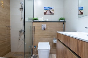 A modern bathroom with a glass shower enclosure, a white toilet, and a wooden vanity with a mirror. - 1BR Sea View | Private Balcony | Maryah Vista (Abu Dhabi)