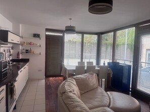 A modern kitchen with a dining area, a sofa, and large windows. - Dublin City Centre Spacious yet Cosy 2B in the Heart of Historic Dublin (Dublin)