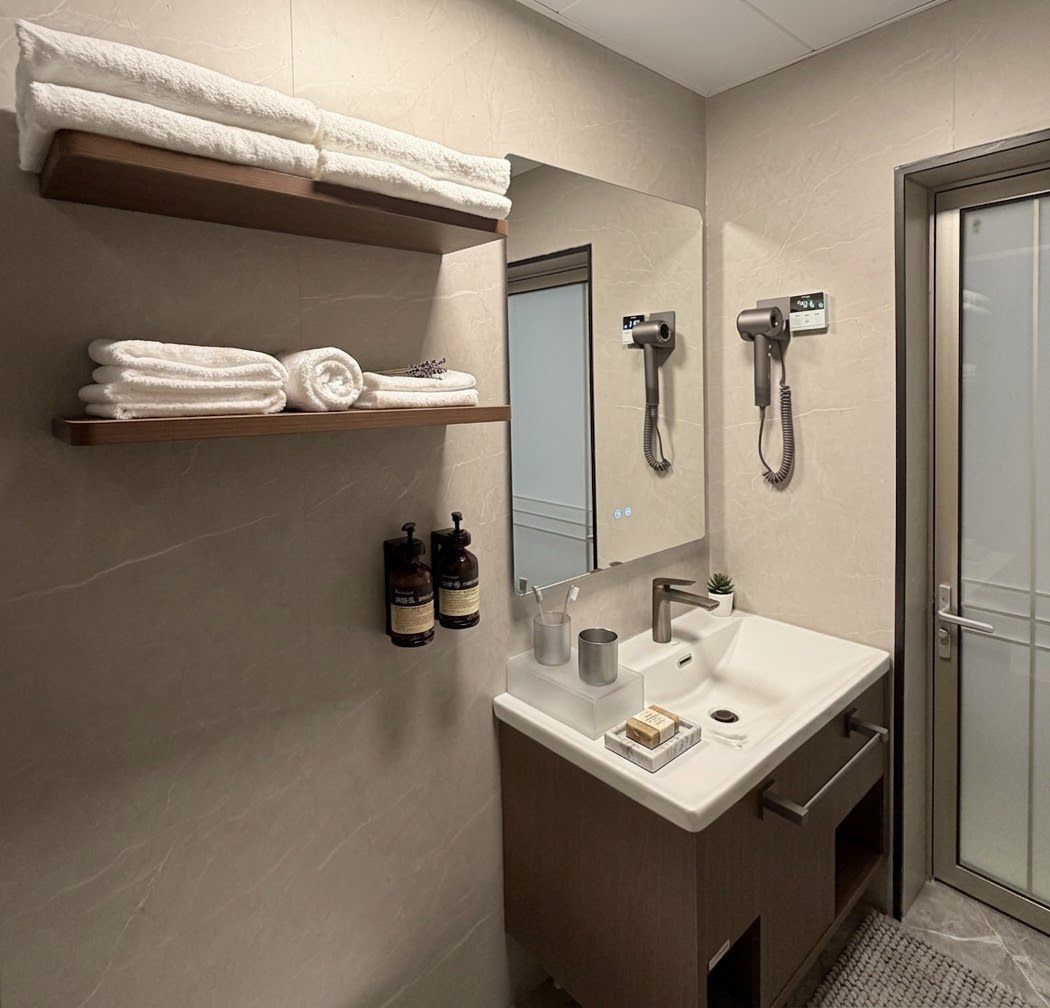 Un baño moderno con tocador, toallero y ducha.