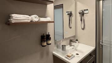 Un baño moderno con tocador, toallero y ducha.