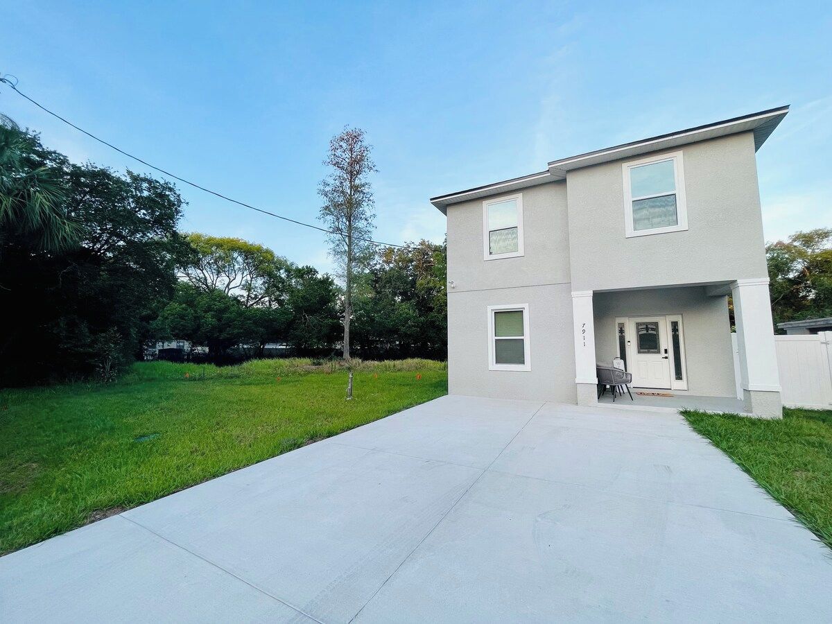 A two-story residential building with a covered front porch and a visible garage door.