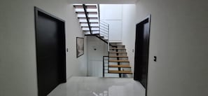 A hallway with a staircase leading to a landing.