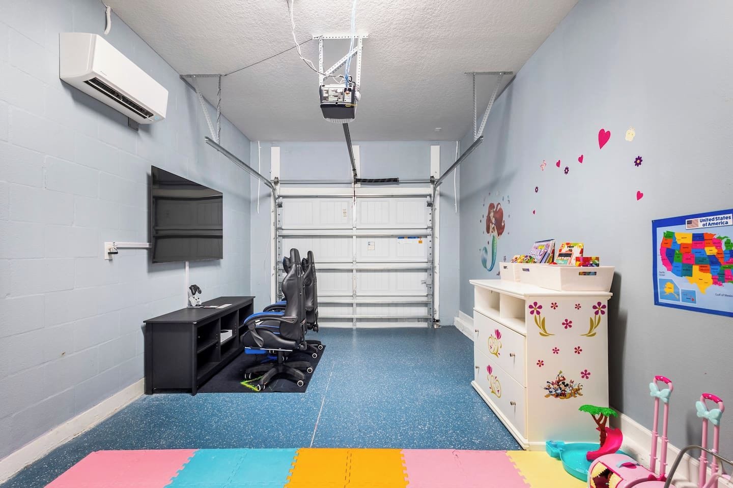 A room with a projector, exercise equipment, a desk, and a wall map.
