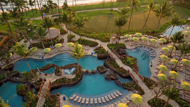 Et resort med flere swimmingpools, palmer og loungeområder.