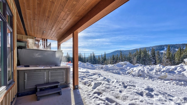A wooden deck with a kitchen area and a view of a snowy landscape. - Switchback Creek by Sun Peaks Alpine Getaways (Sun Peaks)