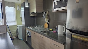 A modern kitchen with stainless steel appliances, a built-in oven, and a microwave. - Apartment in Downtown Temuco (Temuco)