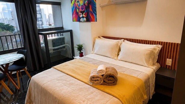 Ein Hotelzimmer mit Bett, Schreibtisch und Blick auf die Stadt.