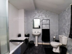 A bathroom with a bathtub, a sink, a toilet, and a shower area. - 74 Trafalgar Square (Scarborough)