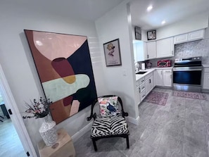 Una cocina moderna con armarios blancos, horno de acero inoxidable y microondas.