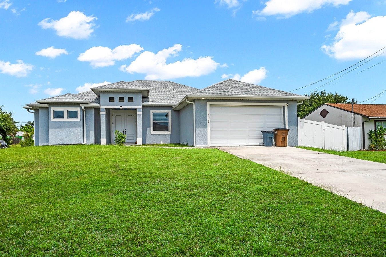 A residential house with a garage, a front yard, and a clear sky.