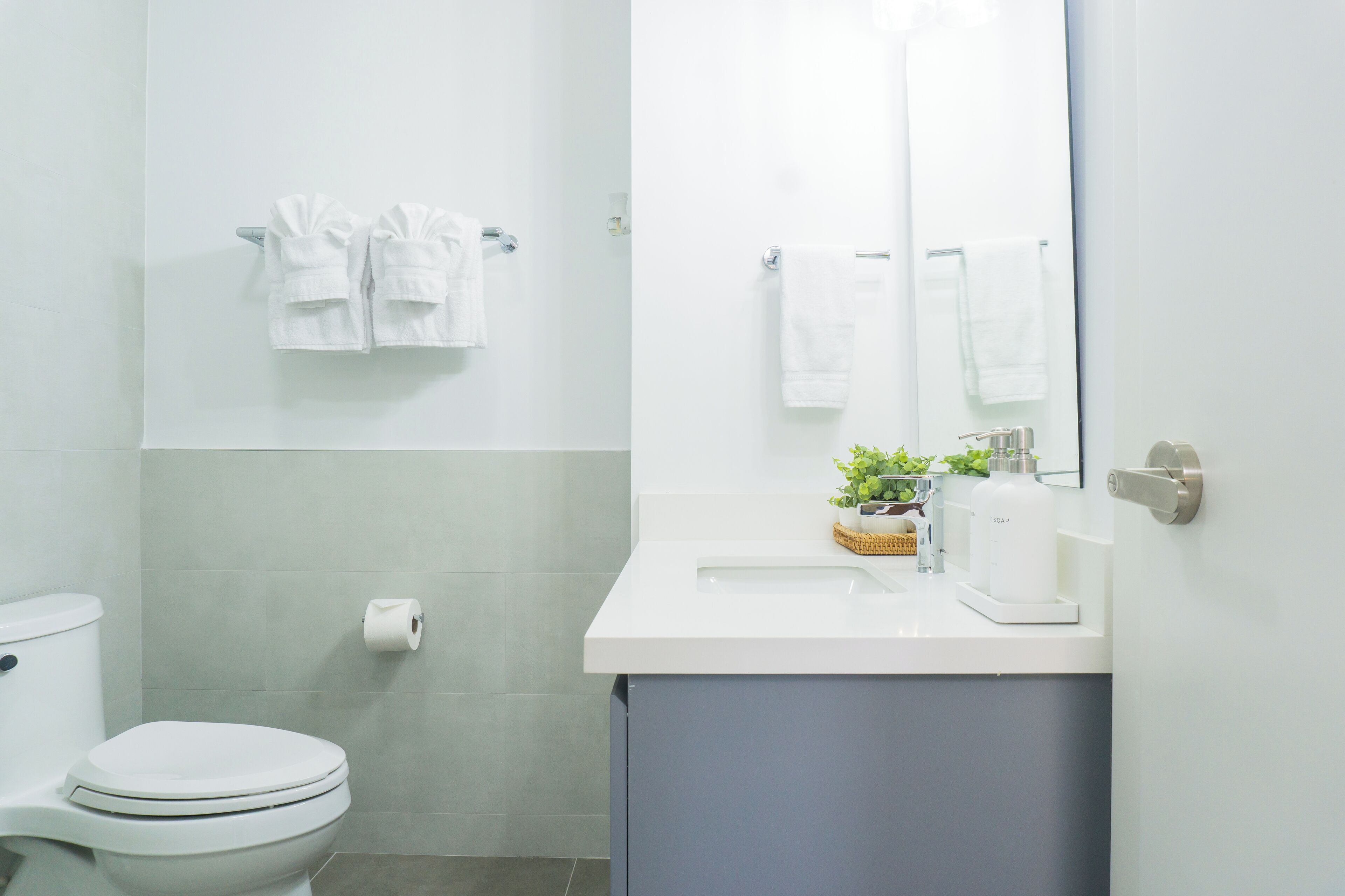 A modern bathroom with a toilet, a sink, and a mirror.