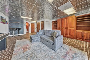 A spacious room with a large sectional sofa, a wooden wardrobe, and a patterned rug. - Gorgeous lake views from every level! (Huddleston)