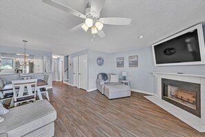 A spacious living room with a fireplace, a dining area, and a kitchen. - Gorgeous lake views from every level! (Huddleston)