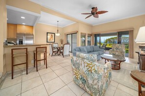 A spacious living area with a kitchen, dining set, and seating arrangements. - Kapalua Golf Villa 25P7 Gold Ocean View 2BD/2BA (Lahaina)
