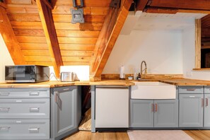 A kitchen with a microwave, toaster, sink, and cabinets. - Fern Haus  Hiking, Hot Tub & River Access (Gold Bar)