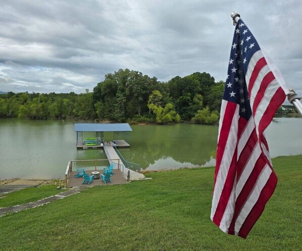A dock with a covered seating area and an American flag.