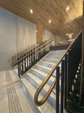 A modern staircase with a metal handrail and wooden steps. - Air Brooklin Residence (São Paulo)