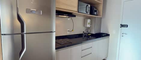 A modern kitchen with built-in appliances, wooden cabinetry, and a countertop.