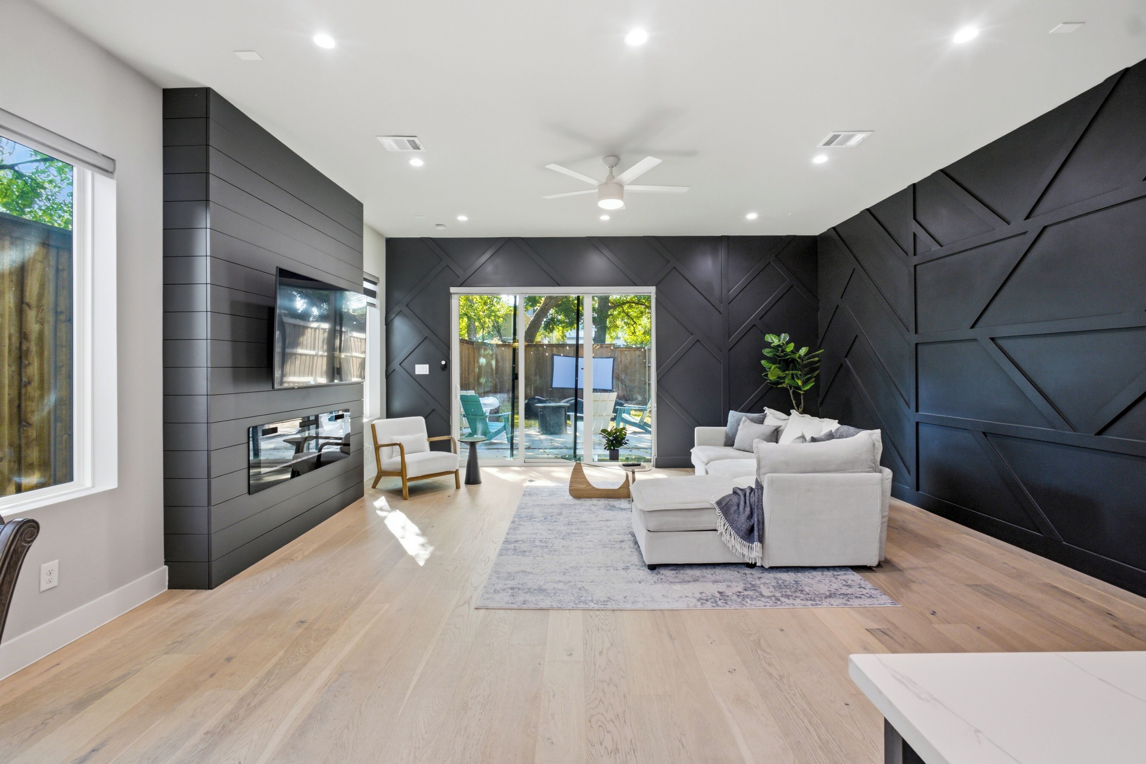 A modern living room with a sofa, a coffee table, and a TV mounted on the wall.