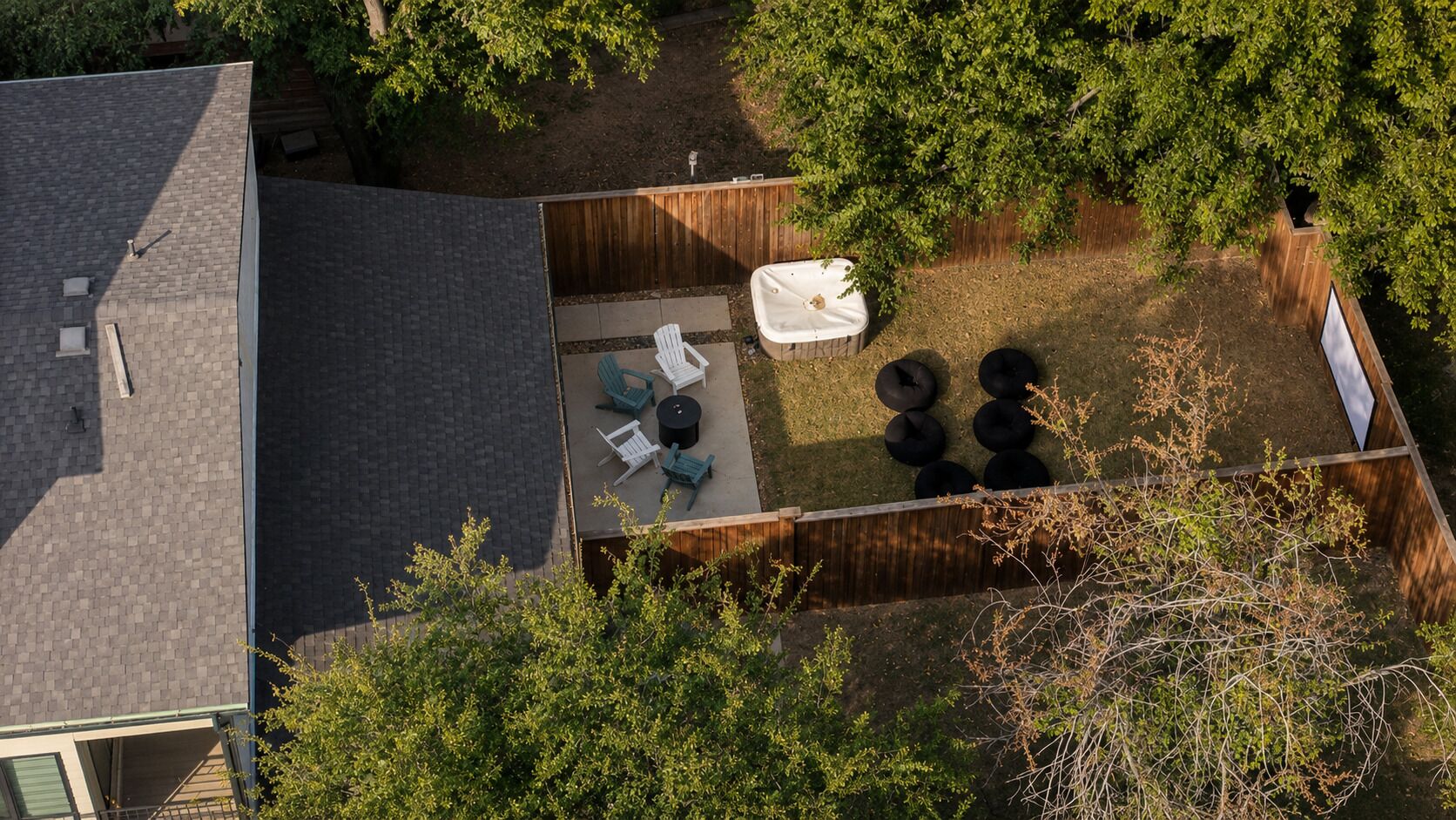 A rooftop patio with a fire pit, seating area, and a hot tub.