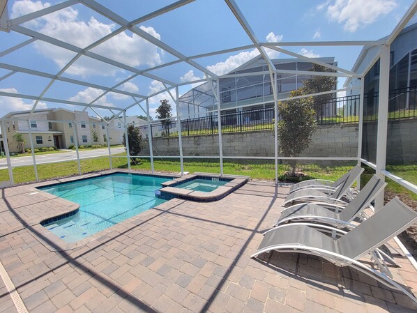 A covered outdoor swimming pool with lounge chairs and a view of a residential area. - Spacious 8-bedroom house in amazing Four Corners with AC (Four Corners)