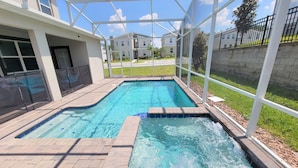 Ein rechteckiger Swimmingpool mit Whirlpool, umgeben von einer überdachten Terrassenfläche.