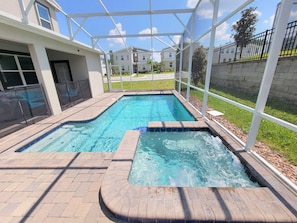 A rectangular swimming pool with a hot tub, surrounded by a covered patio area. - Spacious 8-bedroom house in amazing Four Corners with AC (Four Corners)
