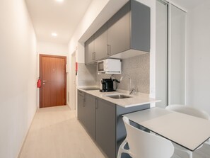 Eine moderne Küche mit Mikrowelle, Kaffeemaschine und Spüle.