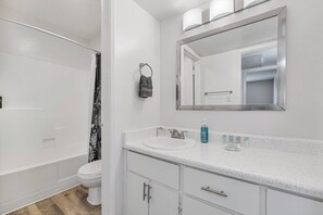 A bathroom with a white sink, mirror, and toilet. - Pool | Gym | Patio | Great For Mid/Long Stays (Mesa)