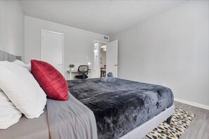 A bedroom with a bed, a desk, and a chair. - Pool | Gym | Patio | Great For Mid/Long Stays (Mesa)