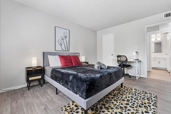 A modern bedroom with a bed, bedside tables, a desk, and a chair. - Pool | Gym | Patio | Great For Mid/Long Stays (Mesa)