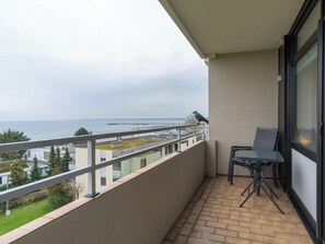 A balcony with a view of the sea, a chair, and a table. - Holiday Apartment in Grossenbrode With Balcony (Grossenbrode)